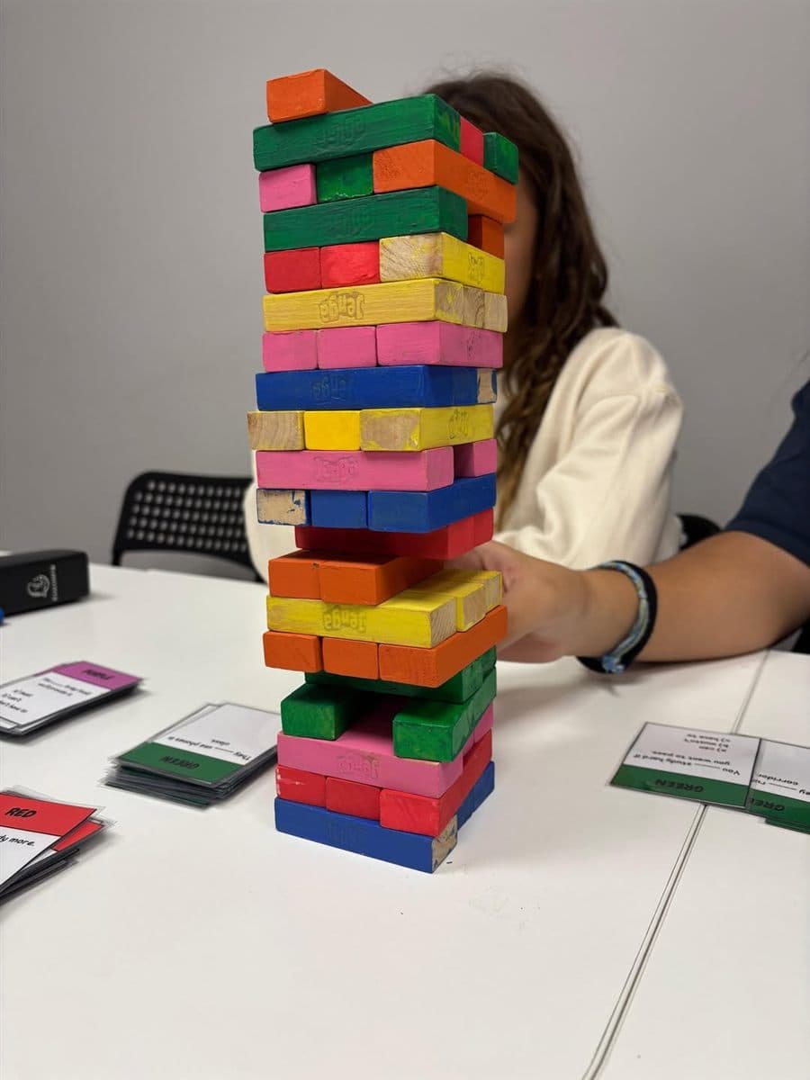 Torre de Jenga de colores durante un juego de repaso con tarjetas de preguntas